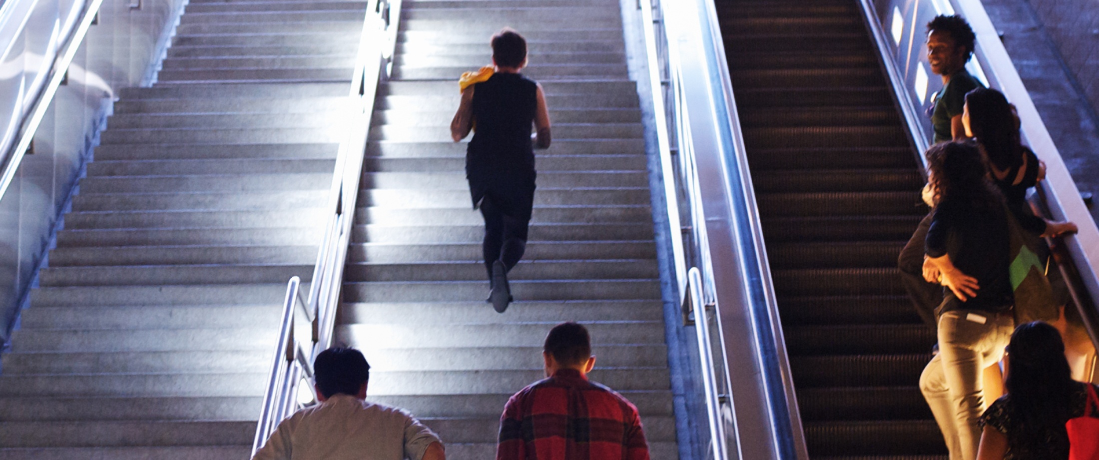 Passengers exiting a Metro station using stairs and escalators.