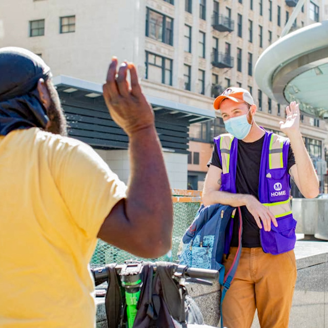 A Metro PATH partner talking to an individual near the station