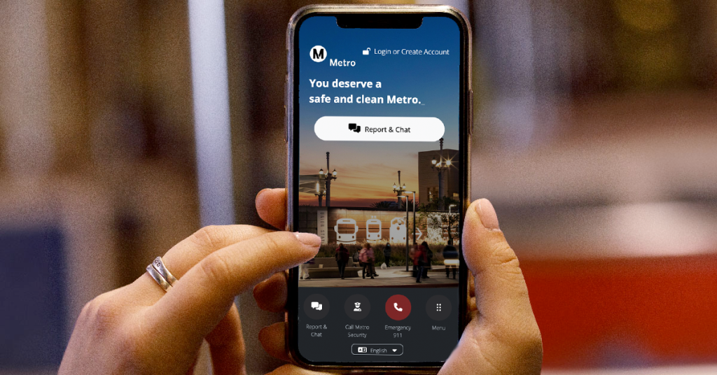 Hands holding mobile phone with Transit Watch app displayed on screen.
